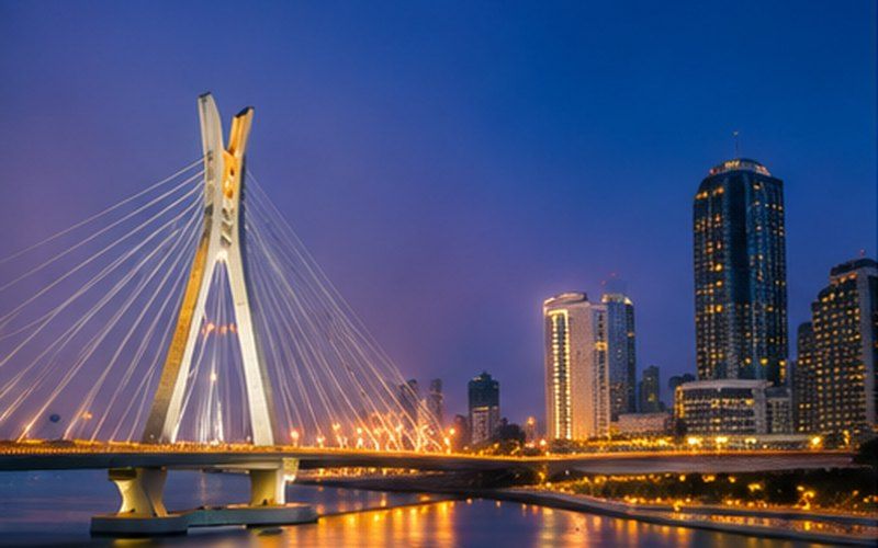 The Lekki–Ikoyi Link Bridge lit over Lagos lagoon at dusk